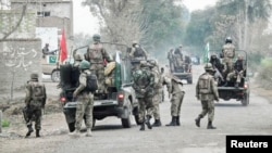 Soldiers arrive and take position near the site of a police station after it was attacked in Bannu, February 14, 2013.