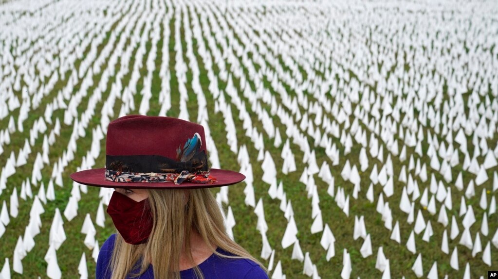 Artist Suzanne Brennan Firstenberg stands among thousands of white flags planted in remembrance of Americans who have died of COVID-19, part of her art installation, near Robert F. Kennedy Memorial Stadium in Washington, D.C., Oct. 27, 2020. (AP)