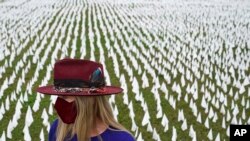 Artist Suzanne Brennan Firstenberg stands among thousands of white flags planted in remembrance of Americans who have died of COVID-19, part of her art installation, near Robert F. Kennedy Memorial Stadium in Washington, D.C., Oct. 27, 2020. (AP)