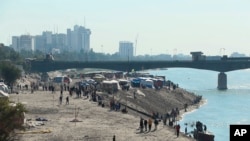 Anti-government protesters gather while security forces close a bridge leading to the Green Zone government areas, during an ongoing protest in Baghdad, Iraq, Sunday, Jan. 26, 2020. 