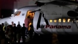 A handcuffed migrant boards a plane for a deportation flight to Ecuador, in the framework of the memorandum of cooperation signed between Panama and the U.S., at the Albrook "Marcos A. Gelabert" International Airport in Panama City, Sept. 20, 2024.