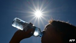 ARCHIVO - Un niño bebe agua de una botella bajo un sol abrasador en Los Ángeles, California, el 30 de agosto de 2022.