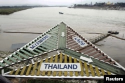 FILE - A signboard at the Thai village of Sop Ruak on the Mekong river in the Golden Triangle region where the borders of Thailand, Laos and Myanmar meet, Jan. 14, 2012.