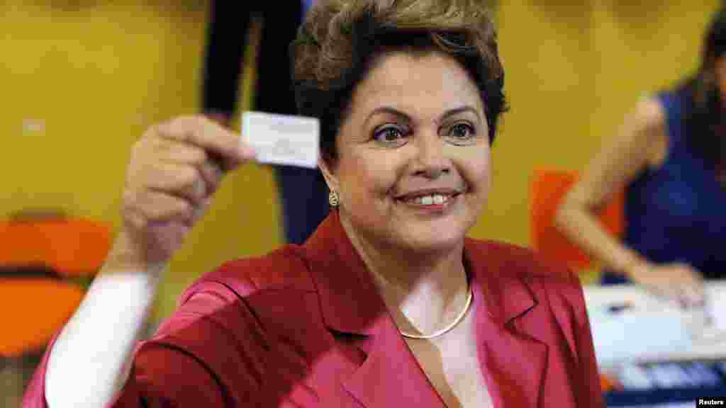 Mgombea kiti wa chama cha Workers' Party (PT) cha Brazil, Dilma Rousseff akionesha cheti chake cha kura katika kituo cha Porto Alegre, Oct. 26, 2014.