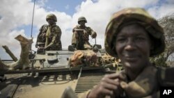  In this photo released by the African Union-UN Information Support Team, Kenyan soldiers with the African Union Mission in Somalia sit on top of an armored vehicle in Saa'moja, north-west of the port city of Kismayo, October 1, 2012. 