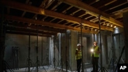 FILE - Builders inspect the construction of an underground version of School No. 88 in Zaporizhzhia, Ukraine, Aug. 30, 2024.