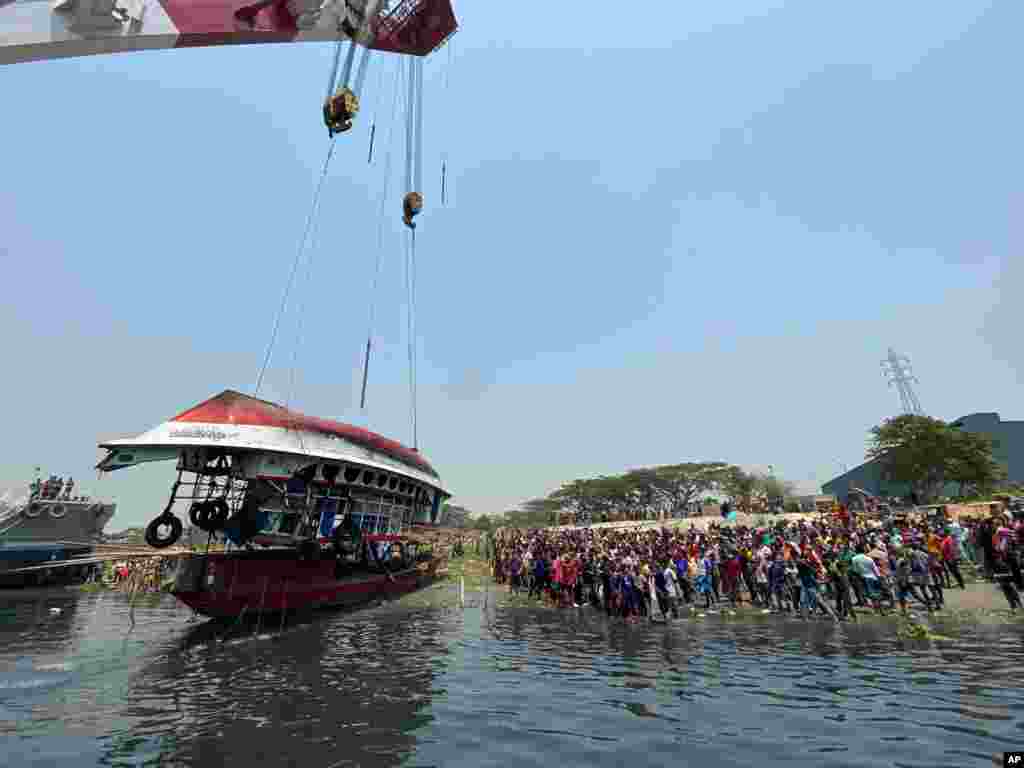 방글라데시 다카에서 전복된 여객선이 수면 위로 올려지고 있다. 지난 4일 여객선이 화물선과 충돌해 최소 25명이 사망했다. 