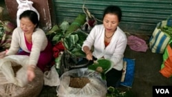 A stall owner in a market in Gangtok city in India's northeast wraps fermented soya beans in a leaf, one of the alternates used in place of plastic for packaging. (A. Pasricha/VOA)