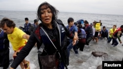 Người phụ nữ Afghanistan kiệt sức tìm kiếm các con khi tới được đảo Lesbos của Hy Lạp ngày 22/10/2015. 