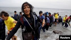 Kauçuk botta zorlu yolculuğun ardından Midilli adasına varan Afgan kadın çocuklarını arıyor. 