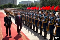 FILE - US Defense Secretary Jim Mattis and China's Defence Minister Wei Fenghe inspect and honour guard during a welcome ceremony at the Bayi Building in Beijing on June 27, 2018.