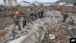 FILE - Workers recover cement blocks from flood-damaged areas in Onsong, North Hamgyong Province, North Korea, Sept. 16, 2016. Amid recent nuclear tensions, Pyongyang is struggling to secure aid for victims of flooding that occurred earlier this month.