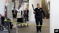 Police stand guard in Terminal 2 after a gunman armed with a semi-automatic rifle opened fire at the airport, killing a Transportation Security Administration employee and wounding two other people, at Los Angeles International Airport, Nov. 1, 2013.