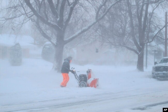 A man is bundled up against bitter wind and blowing snow as he operates a snowblower, Jan. 30, 2019, in Buffalo, N.Y. The area received more than a foot of snow since Tuesday and was under a blizzard warning.