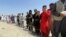 People wait outside Hamid Karzai International Airport in Kabul