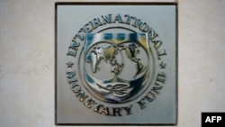 FILE: The seal of the International Monetary Fund (IMF) is seen at its headquarters in Washington, DC. The IMF has received a request for aid from Tunisia., with discussions slated for early July. 