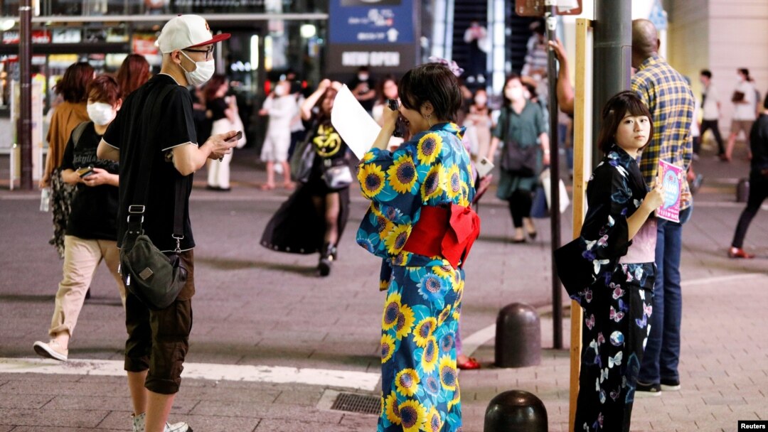 Women in summer kimonos advertise for a bar that stays open after 8 p.m., when most of the restaurants and bars in the Kabukicho nightlife area close due to the state of emergency amid the COVID-19 pandemic, in Tokyo, Japan July 31, 2021. 