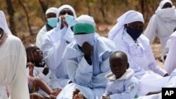 Miembros de la Iglesia Crisitana Apostólica participan en un servicio al aire libre en las afueras de Harare, la capital de Zimbabue, el 19 de septiembre del 2021. La iglesia es una de las más escépticas respecto a las vacunas contra el COVID-19. (AP Photo/Tsvangirayi Mukwazhi)