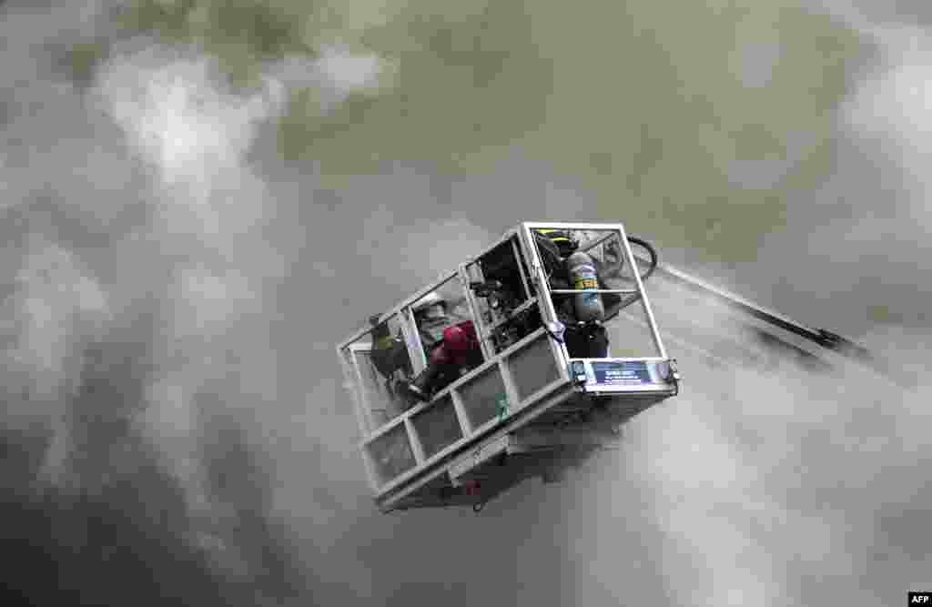 Heavy smoke engulfs firemen on board a firetruck basket as they battle a fire that hit the Waterfront Manila Pavilion building, a hotel and casino complex in Manila, Philippines. Five people have perished in a raging inferno that tore through a hotel and casino complex in Manila, authorities said after firefighters battled more than 24 hours to douse the flames.