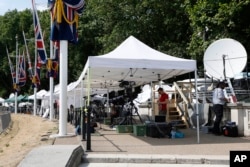 Broadcast media prepare to report from outside Buckingham Palace in London where a notice announcing the birth of the baby will be posted, July 22, 2013.