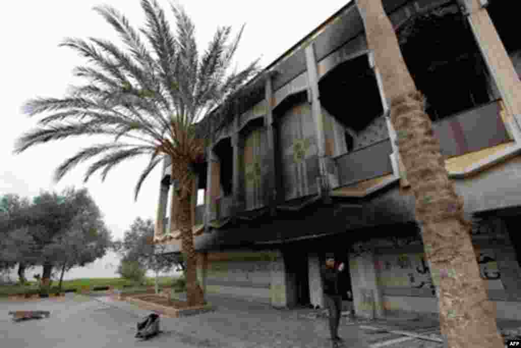 A Libyan youth takes a picture of Gadhafi's burned residence at the stormed al-Katiba base in Benghazi, Libya Tuesday, March 8, 2011.