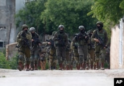 Israeli forces search for a Palestinian gunman in the village of Bruqin near the West Bank town of Salfit, March 17, 2019. The Israeli military says a Palestinian killed an Israeli and seriously wounded two others.