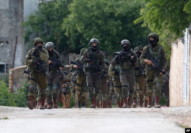 Israeli forces search for a Palestinian gunman in the village of Bruqin near the West Bank town of Salfit, March 17, 2019. The Israeli military says a Palestinian killed an Israeli and seriously wounded two others.