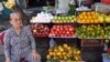 FILE - A woman sells fruit at a stand in Ho Chi Minh City.