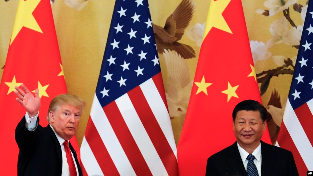 FILE - U.S. President Donald Trump waves next to Chinese President Xi Jinping after attending a joint press conference at the Great Hall of the People in Beijing.