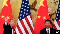 FILE - U.S. President Donald Trump waves next to Chinese President Xi Jinping after attending a joint press conference at the Great Hall of the People in Beijing. 