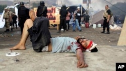 Seorang demonstran yang terluka tergeletak di jalanan di tengah sweeping oleh tentara Mesir di Lapangan Nahda, Kairo (14/8).