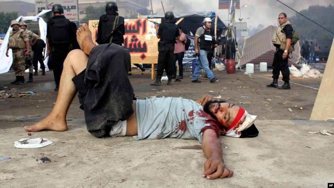 Seorang demonstran yang terluka tergeletak di jalanan di tengah sweeping oleh tentara Mesir di Lapangan Nahda, Kairo (14/8).