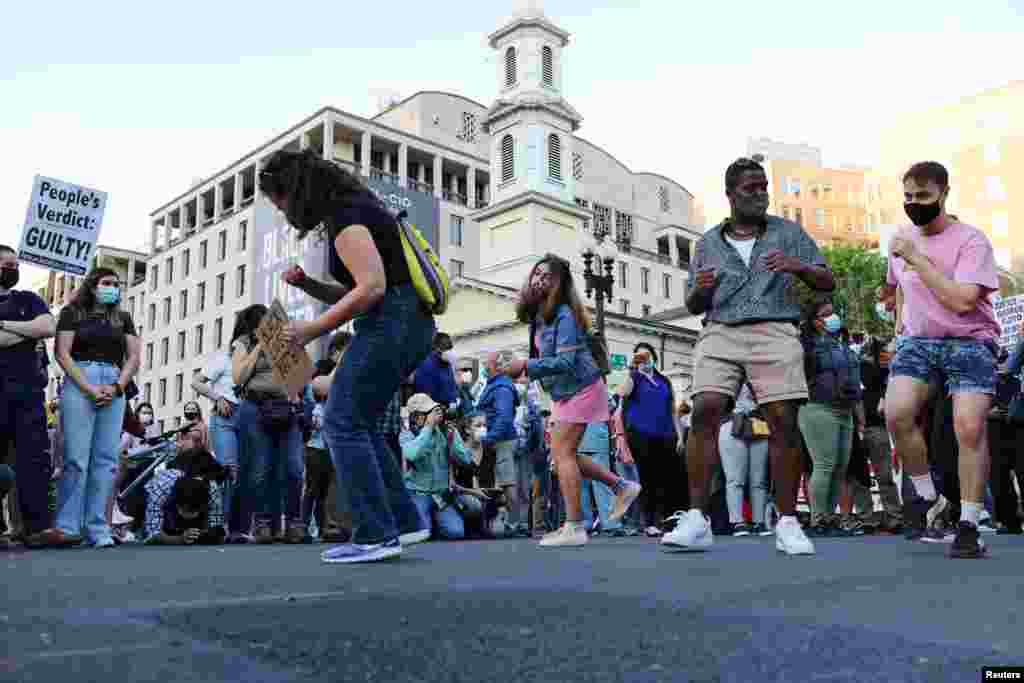 Pessoas dançam na Black Lives Matter Plaza em Washington DC, celebrando o veredicto do julgamento de Derek Chauvin, o polícia que matou George Floyd em 25 de Maio de 2020, em Mineapolis. 20 de Abril de 2020