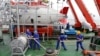 FILE - Staff work on a boat in front of the China's manned deep-diving submersible "Jiaolong" in Jiangyin, Jiangsu province July 1, 2011.