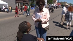 Anita Johnson, who works with the Democracy 2020 coalition in Wisconsin, discusses voting law changes at a Milwaukee street festival in June. (J. Swicord/VOA)
