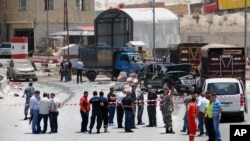 Lebanese army and plainclothes policemen gather at the site of an explosion near a police checkpoint in the eastern town of Dahr el-Baidar, Lebanon, June 20, 2014.