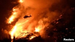 A Los Angeles County fire helicopter makes a night drop while battling the so-called Fish Fire above Azusa, California, June 20, 2016.