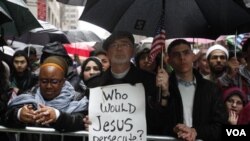 Mark Lukens, seorang pendeta dari gereja Bethany, New York, membawa poster mendukung warga Muslim Amerika dari penggambaran buruk di dalam negeri.