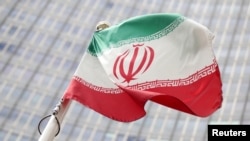 FILE - The Iranian flag flutters in front the International Atomic Energy Agency (IAEA) headquarters in Vienna, Austria.