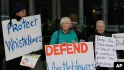 FILE - Protesters demonstrate outside a court in Canberra, Australia, on June 27, 2019. A former army lawyer was being charged with leaking secret documents to Australian Broadcasting Corp. reporters.