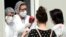 A medical staff attends to a woman as she arrives to test for coronavirus, at a hospital in Sarajevo, Bosnia and Herzegovina, 06 July 2020. 