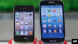File - Samsung Electronics' Galaxy S III (R) and Apple's iPhone 4S displayed at a mobile phone shop in Seoul, South Korea, Aug. 24, 2012.
