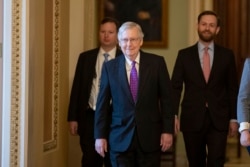 FILE - Senate Republican Majority Leader Mitch McConnell, center, leaves the Senate Chamber on Capitol Hill, in Washington, Feb. 4, 2020.