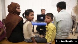 Satu keluarga pengungsi Rohingya menunggu proses pendaftaran oleh petugas pengungsi PBB (UNHCR) di kamp Kutupalong, Bangladesh. 