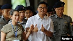 Detained Reuters journalist Wa Lone walks with his wife Pen ei mon as he arrives at Insein court in Yangon, Myanmar, July 23, 2018.