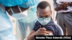 Le ministre de la santé, Benjamin Hounkpatin prend sa dose de vaccin contre le Covid-19 à Cotonou, Bénin, le 15 juin 2021. (VOA/Ginette Fleur Adandé)