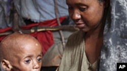 An internally displaced Somali woman holds her malnourished child inside their temporary home in Hodan district, south of Somalia's capital Mogadishu, September 20, 2011.