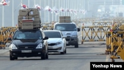 북한이 개성공단 출경을 불허한 지난 4월 입경한 개성공단 근로자들이 차량 지붕에 짐을 가득 싣고 통일대교를 건너고 있다.