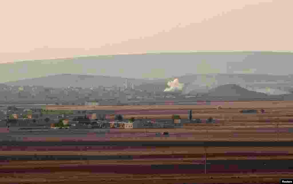 Smoke rises from the Syrian town of Kobani during what activists said were clashes between Islamic State fighters and Kurdish fighters, as seen from a hill in Tal-Hajeb village that overlooks the town, October 7, 2014.