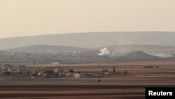 Asap membumbung dari kota Kobani, Suriah, dalam pertempuran antara pasukan Kurdi dengan tentara ISIS (7/10).